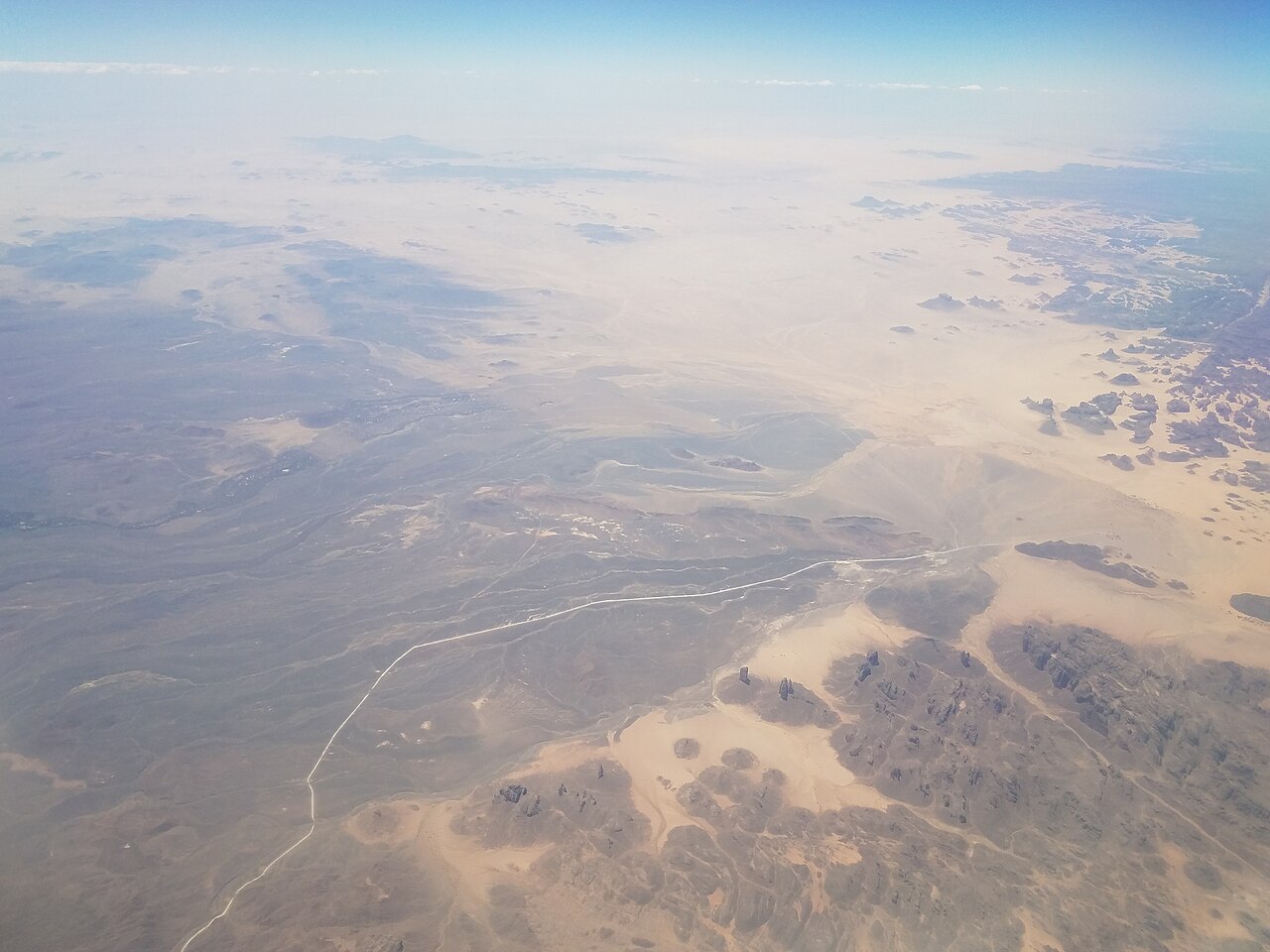 Vue aérienne de dunes et de reliefs rocheux du désert chaud du Tassili n’Ajjer.